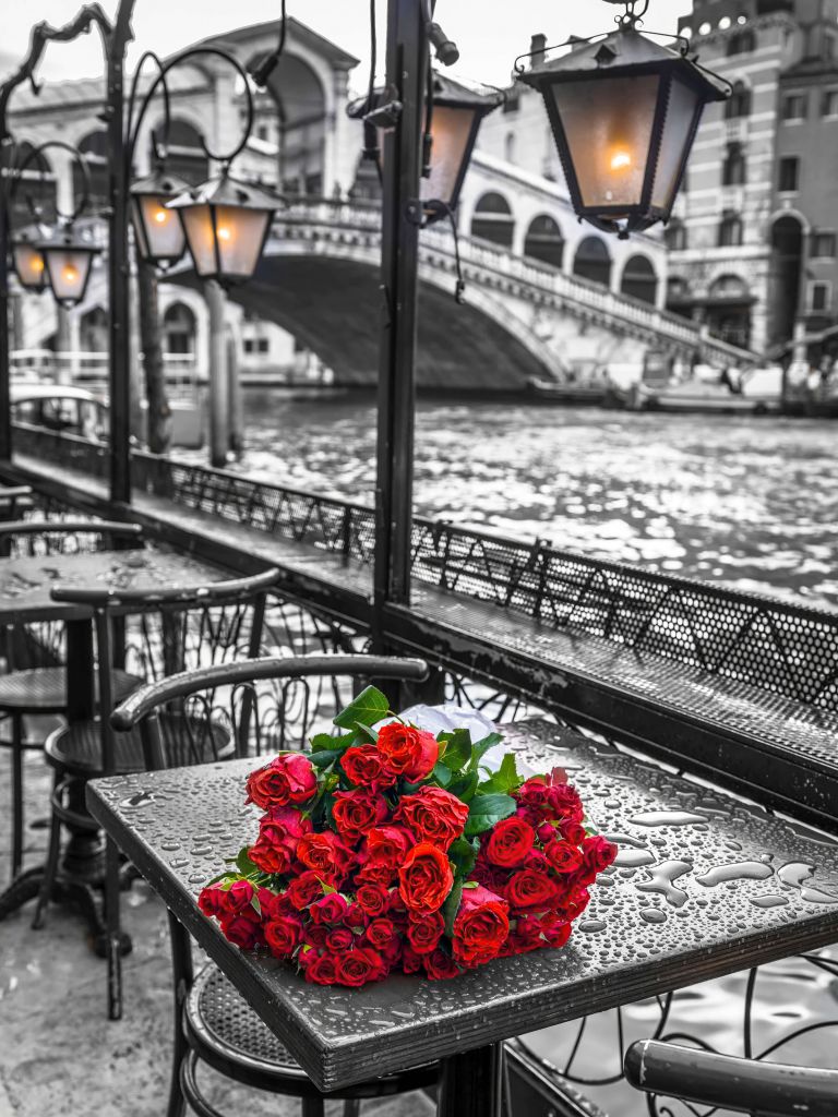 Bunch of red roses on street cafe table, Rialto Bridge, Venice, Italy