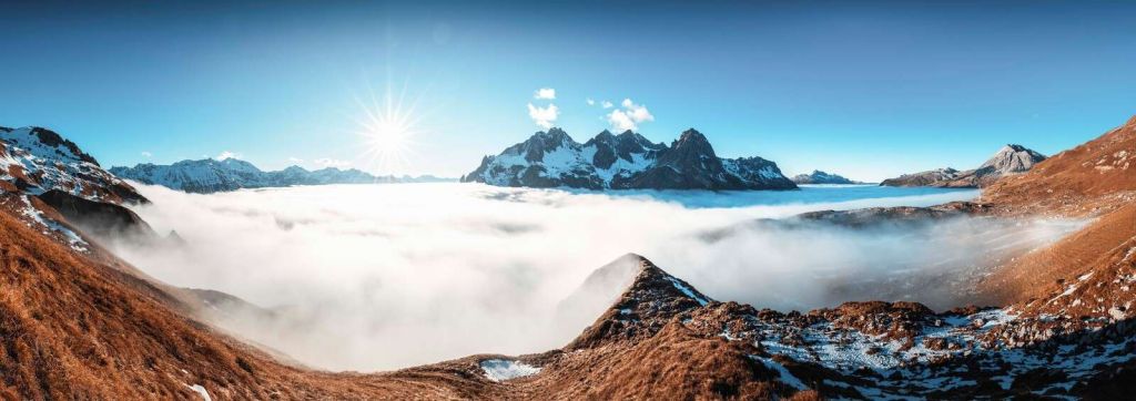 Vallée de montagne ensoleillée avec mer de nuages