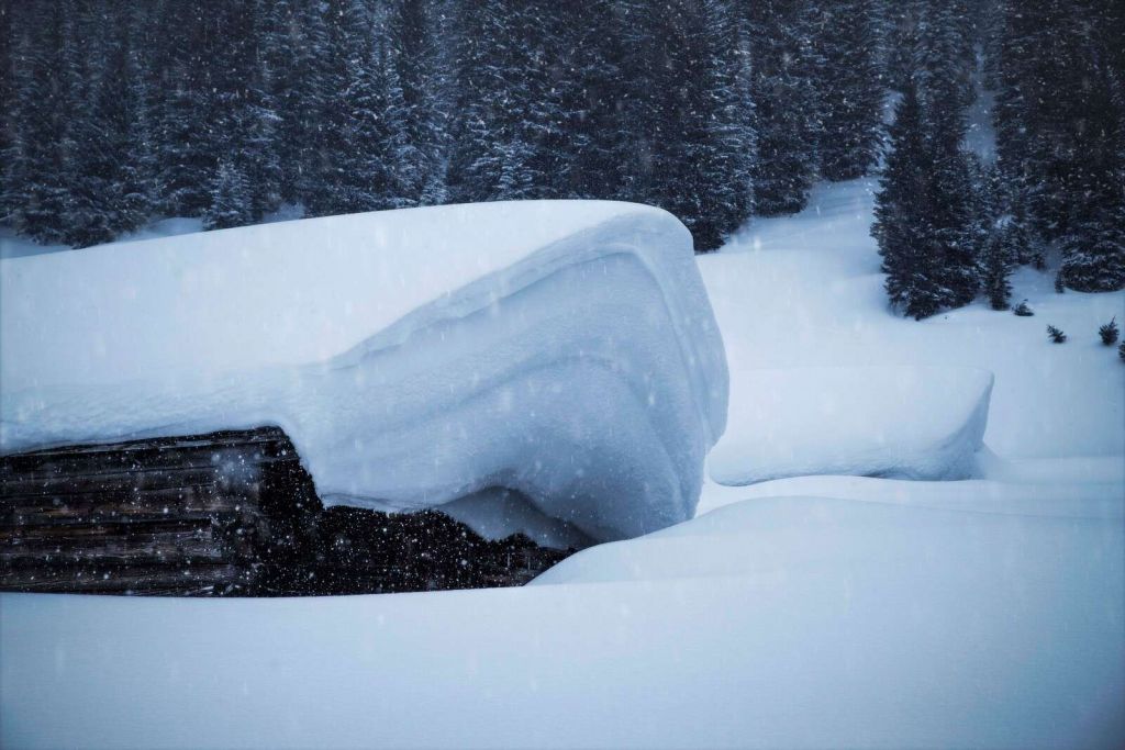 Chalet alpin enneigé dans la tempête d'hiver