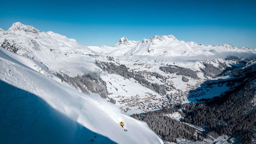 Descente au-dessus du village alpin dans la neige.