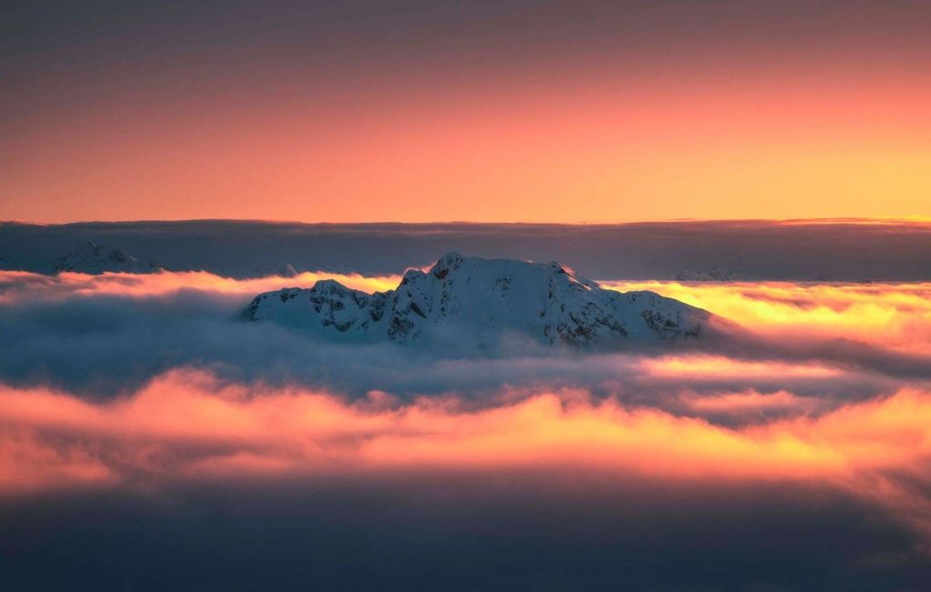 Sommet enneigé dans une mer de nuages