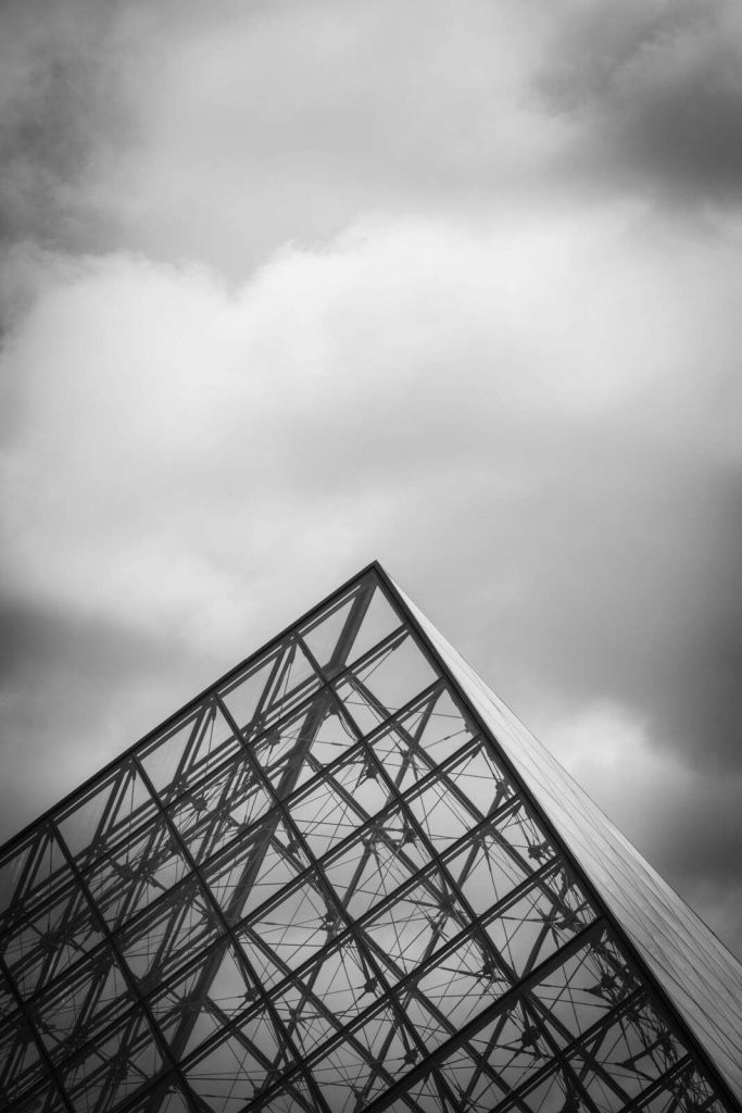Pyramide de verre sous un ciel nuageux