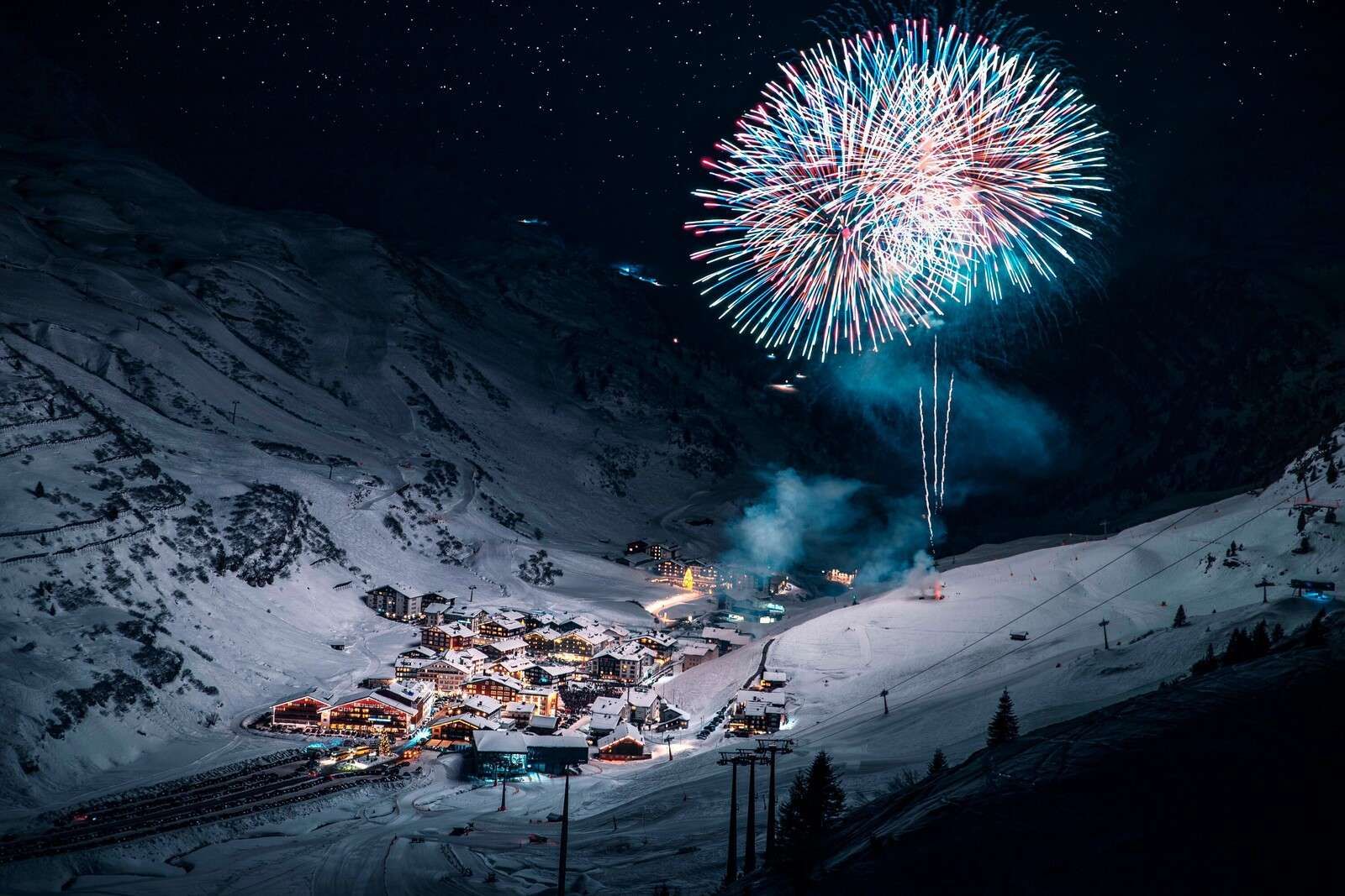 Feu d'artifice au-dessus d'un village de montagne en hiver