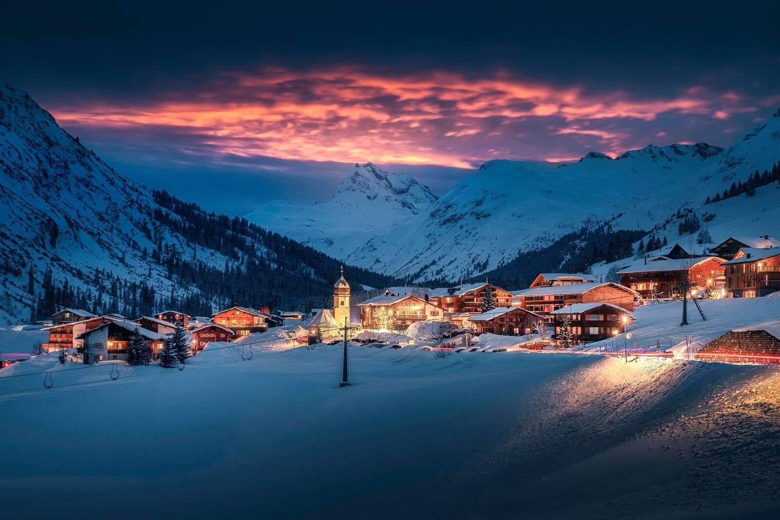 Lumière du soir sur un village de montagne enneigé