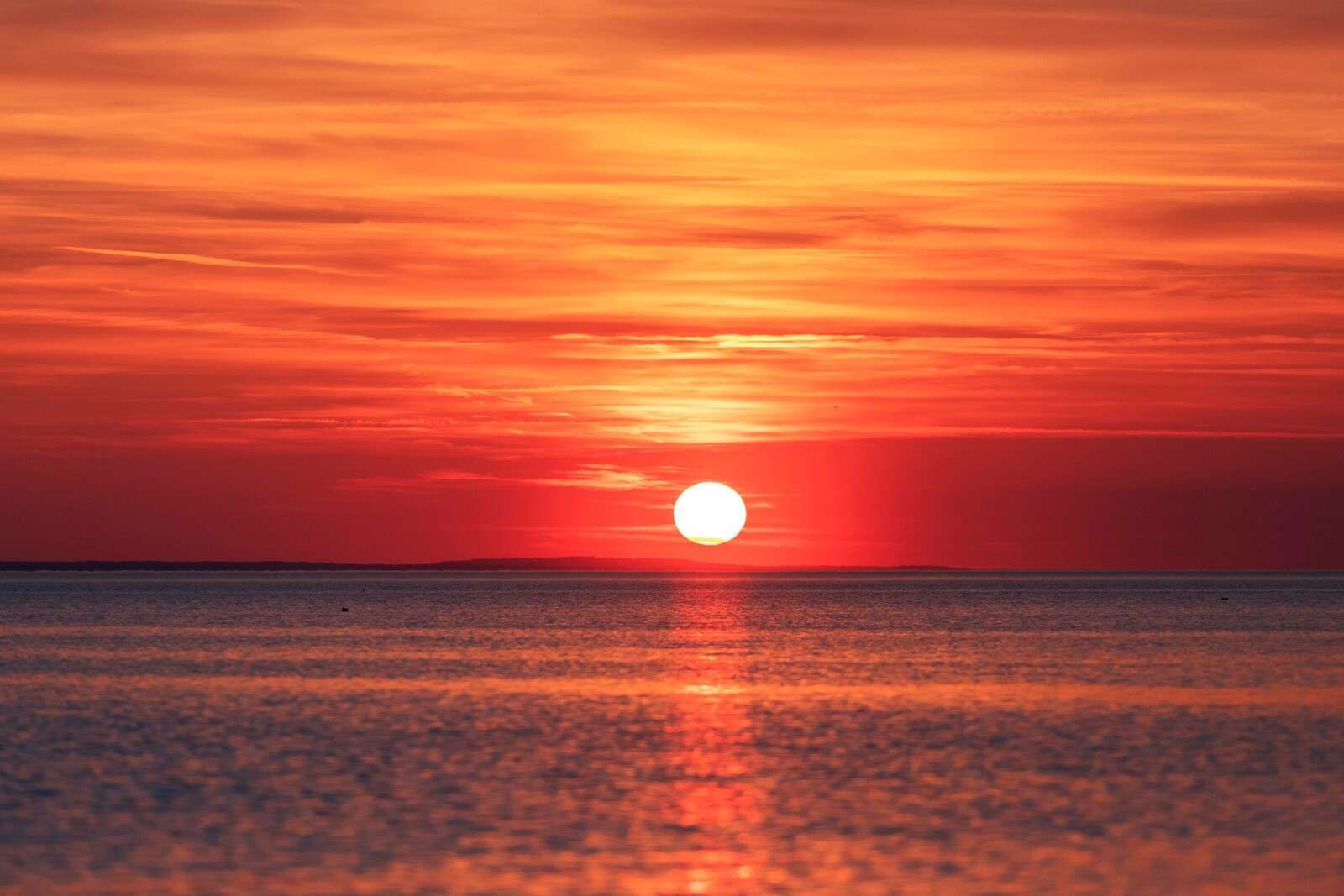 Coucher de soleil rouge feu sur une mer calme